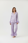 FEMME CLAIRE  DEBOUT EN STUDIO AVEC ENSEMBLE DE PYJAMA SATINE ELEGANT VIOLET CLAIRE AVEC BOUTON AVEC PLUME SUR LES MANCHETTE ET SUR LE BAS DU PANTALON